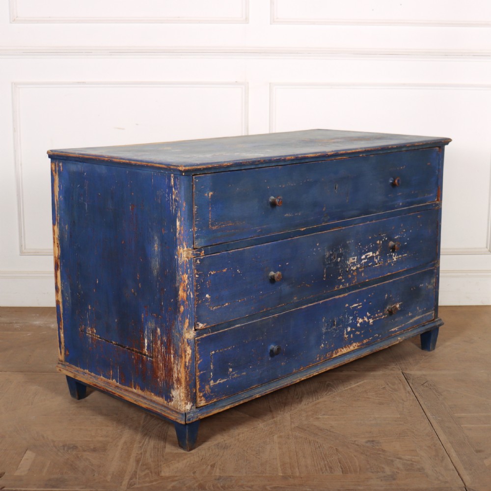A three-drawer wooden chest of drawers featuring a weathered blue painted finish, small turned knobs, and square tapered feet. View VII