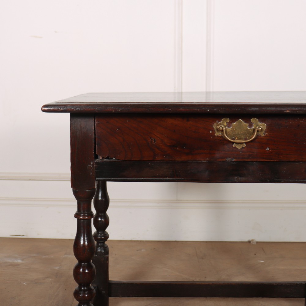 An 18th-century dark oak lamp table featuring turned legs, a single drawer with a brass handle, and low stretchers. View III