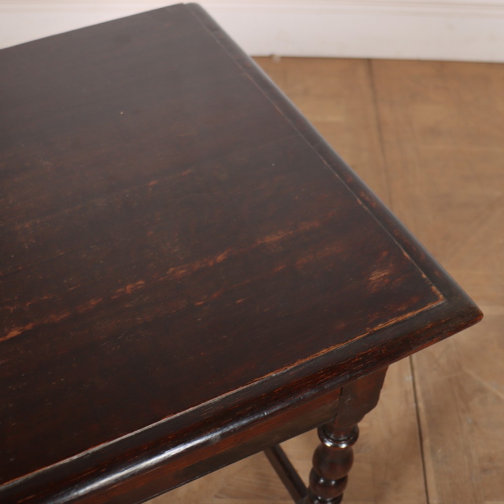 An 18th-century dark oak lamp table featuring turned legs, a single drawer with a brass handle, and low stretchers. View VIII