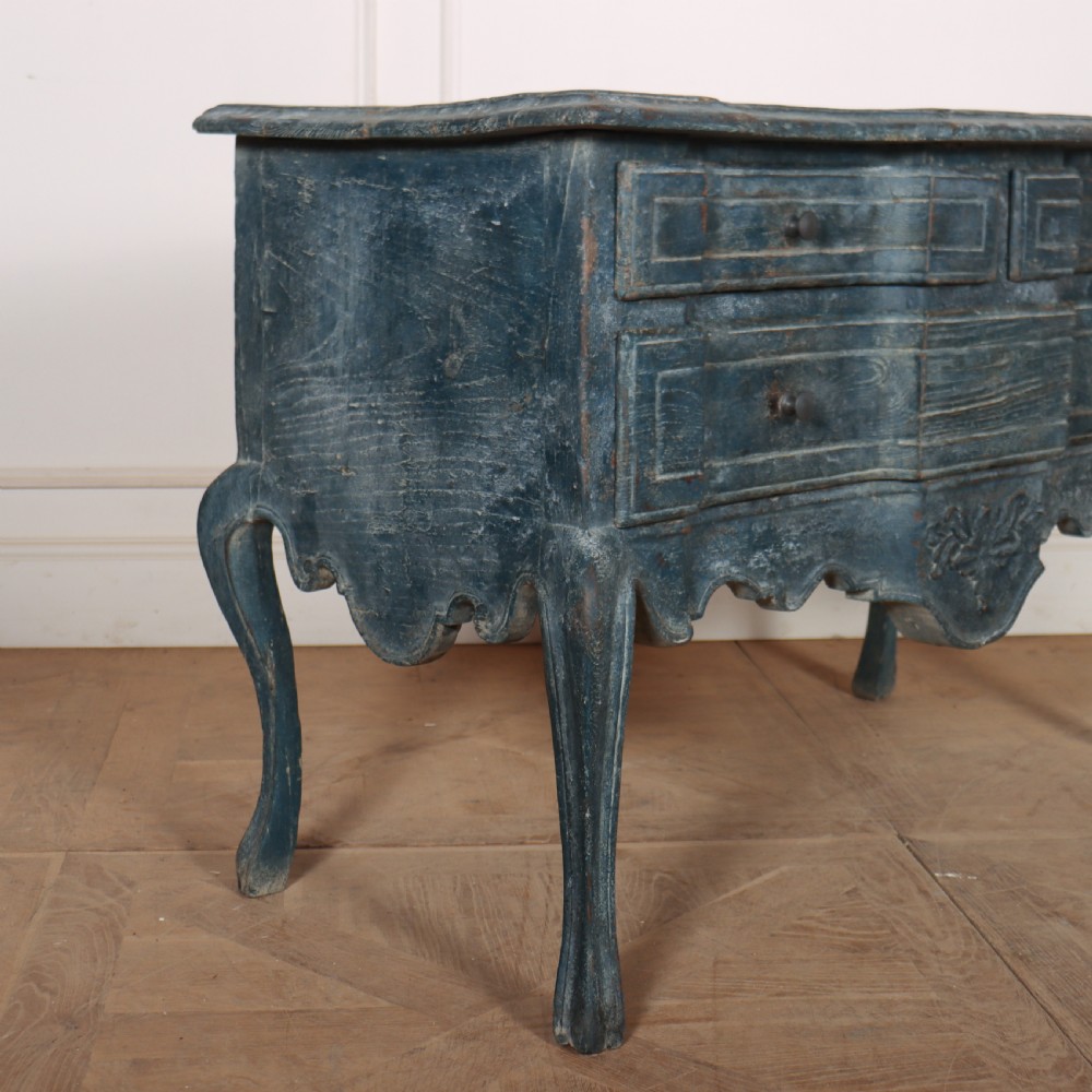 An 18th-century Portuguese serpentine commode featuring a blue painted finish, cabriole legs, and a carved apron. View V