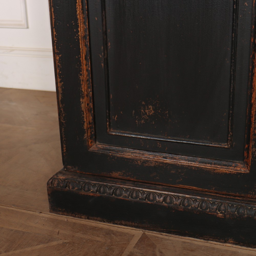 A tall black painted antique bookcase featuring three upper doors with gold-tone brass lattice grilles over three solid panelled lower cupboard doors. View III