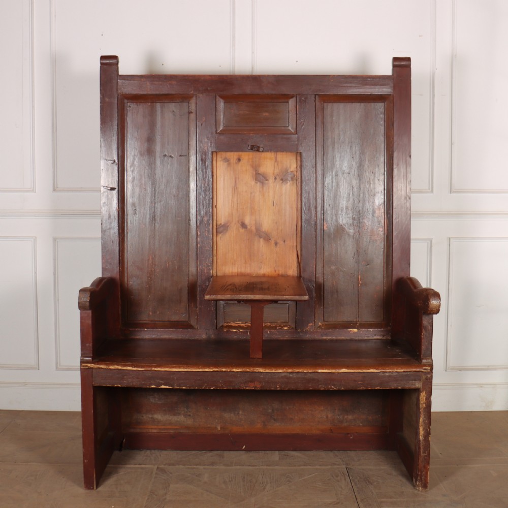 An 18th-century Spanish high-backed settle crafted from dark reddish-brown painted wood with raised back panels and integrated armrests. View V