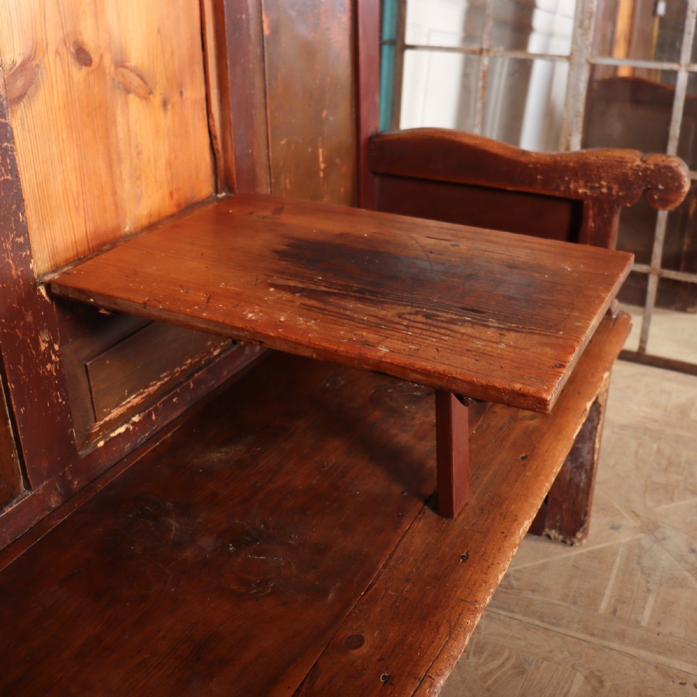 An 18th-century Spanish high-backed settle crafted from dark reddish-brown painted wood with raised back panels and integrated armrests. View VI