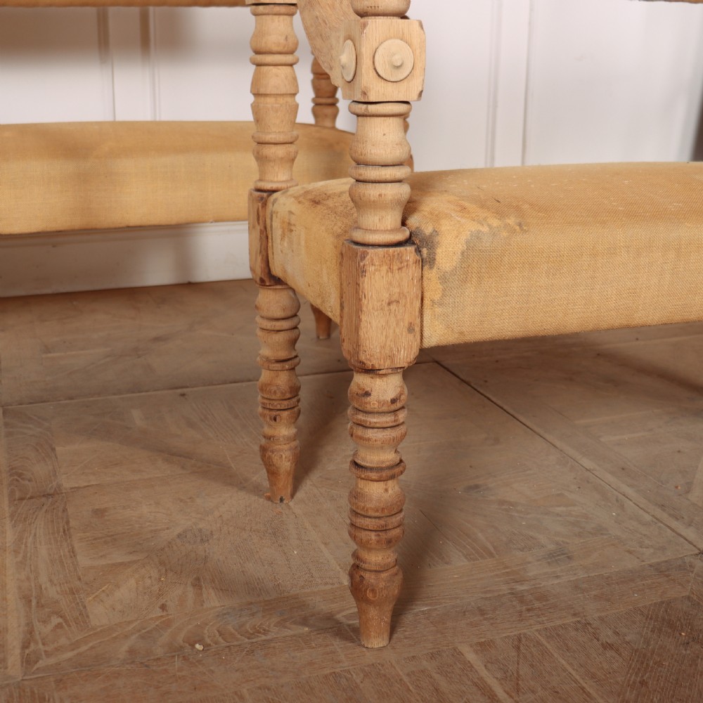 Pair of French bleached oak settles with turned legs, carved rosette details, and neutral canvas upholstery. View II