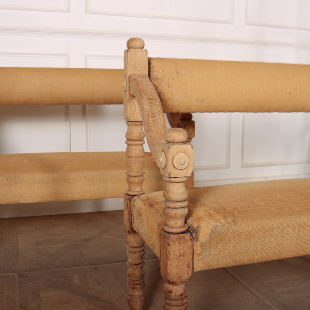 Pair of French bleached oak settles with turned legs, carved rosette details, and neutral canvas upholstery. View V