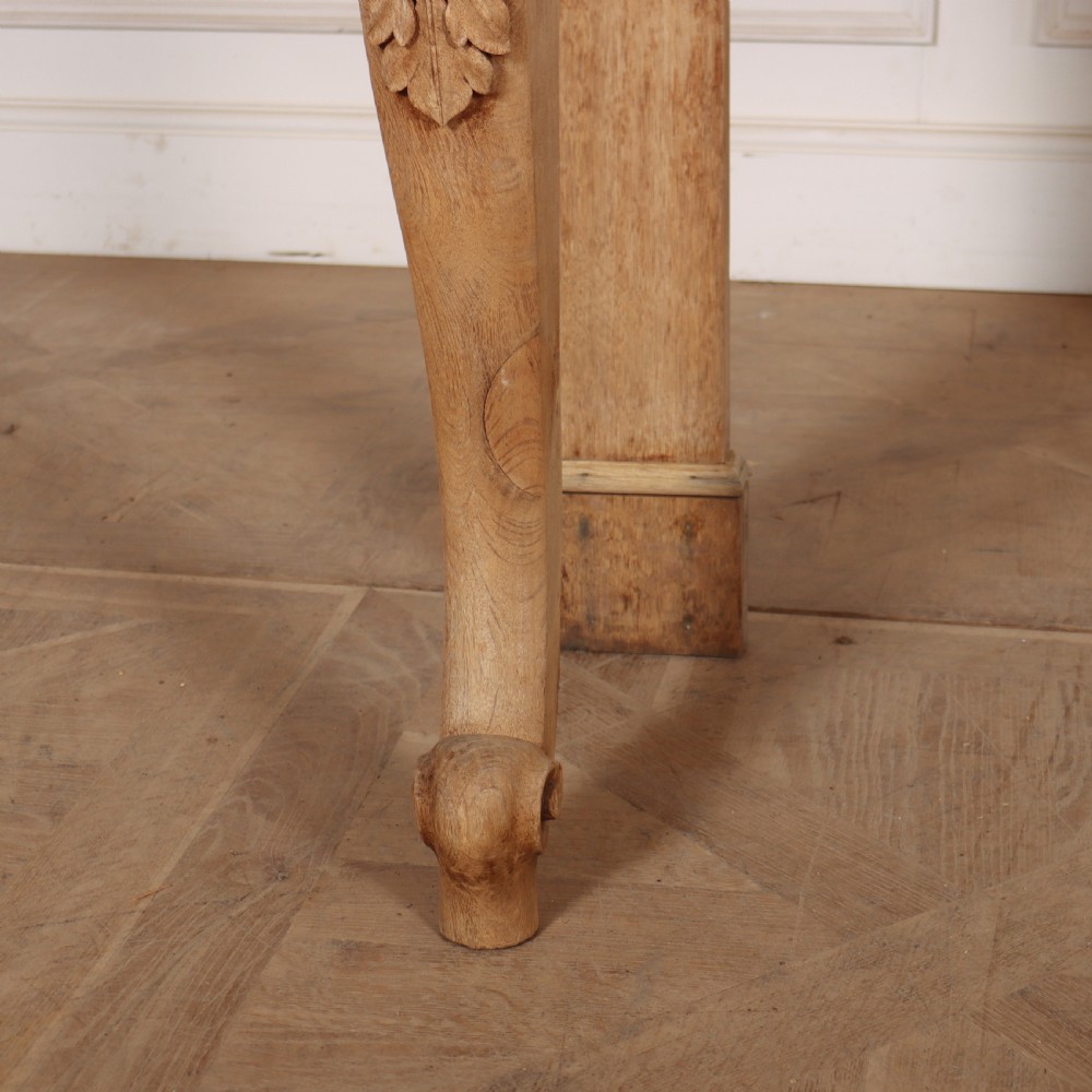 A light tan bleached oak console table with a low pedimented upstand and carved acanthus leaf front legs. View III