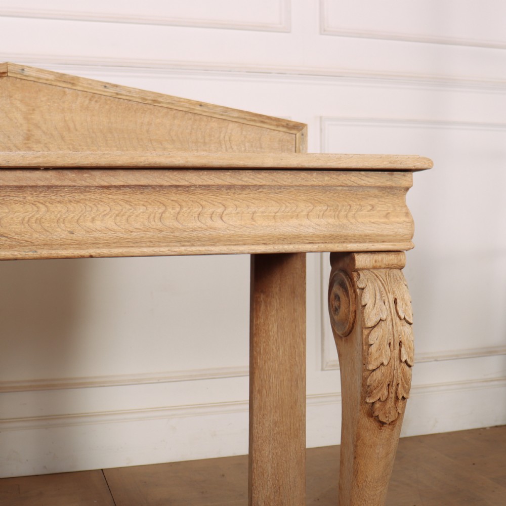 A light tan bleached oak console table with a low pedimented upstand and carved acanthus leaf front legs. View IV