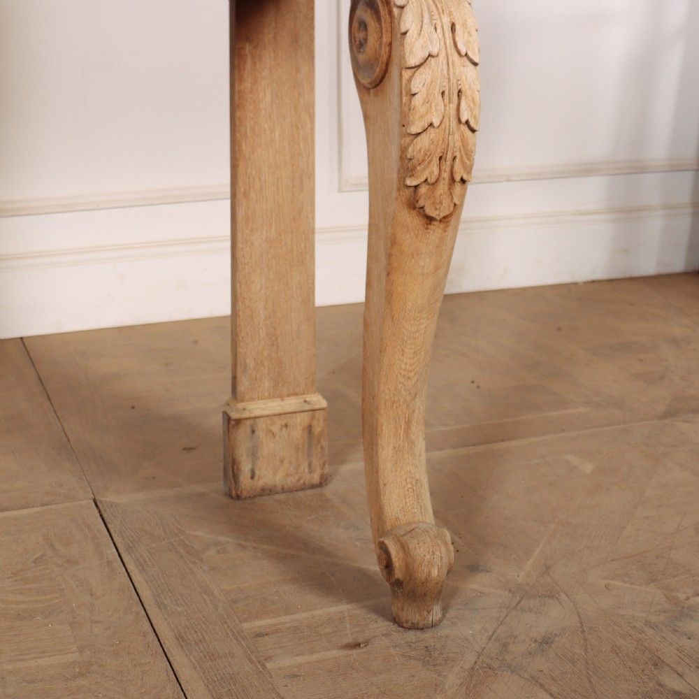 A light tan bleached oak console table with a low pedimented upstand and carved acanthus leaf front legs. View V