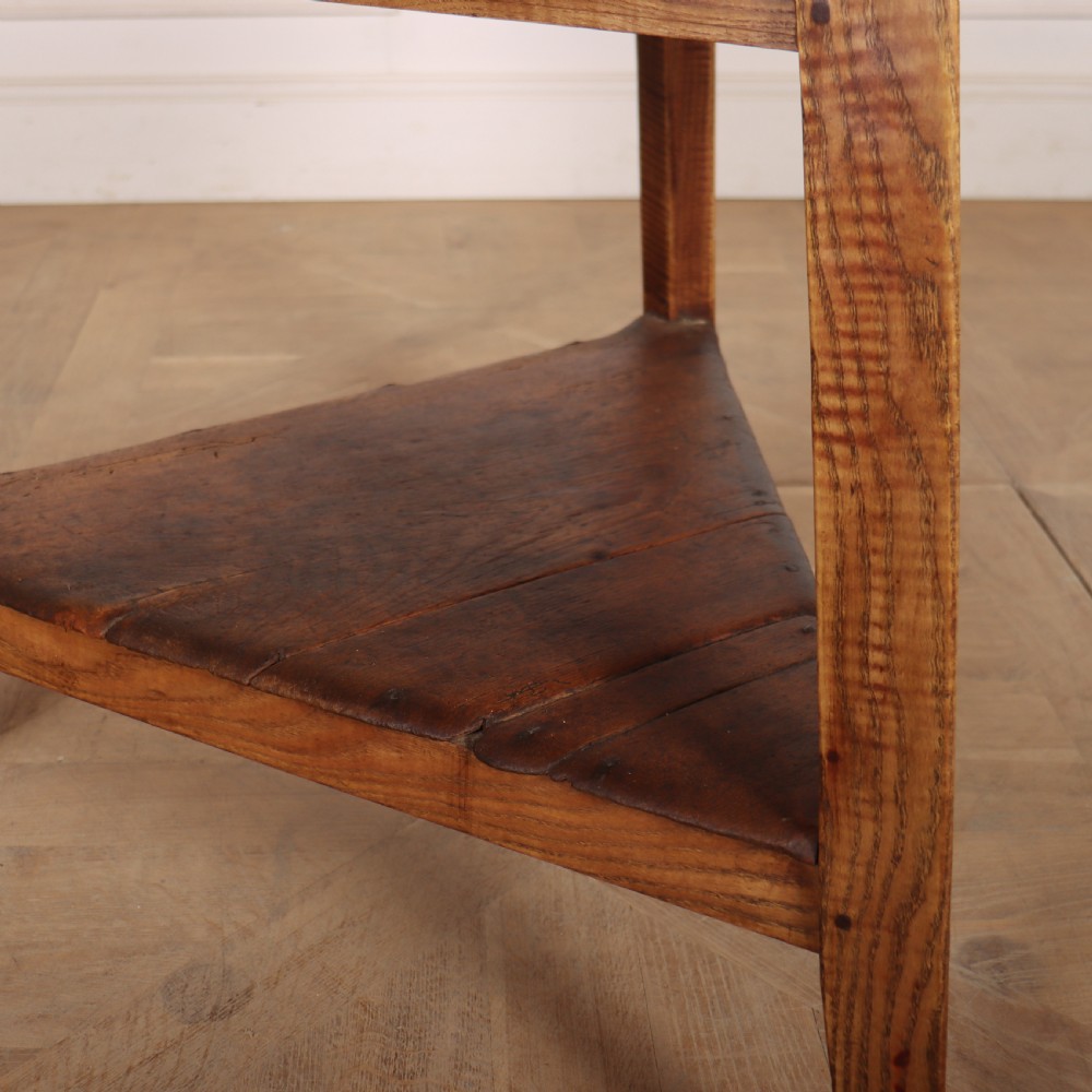 A nineteenth-century Welsh cricket table featuring a circular white marble top supported by a three-legged wooden frame with a lower triangular shelf. View II