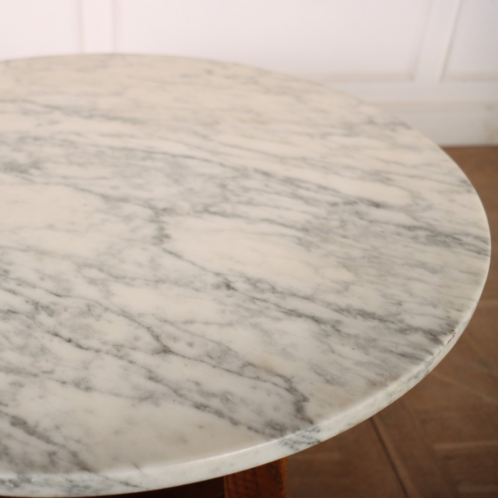 A nineteenth-century Welsh cricket table featuring a circular white marble top supported by a three-legged wooden frame with a lower triangular shelf. View IV