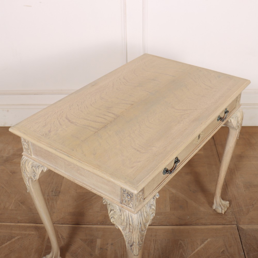 A bleached oak lamp table featuring carved cabriole legs with claw-and-ball feet, acanthus knee carvings, and a single drawer with twin brass drop handles. View VI