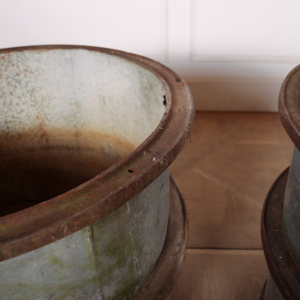 A pair of cylindrical weathered zinc planters featuring rusty iron rims and mid-bands with a distressed aged finish. View IV