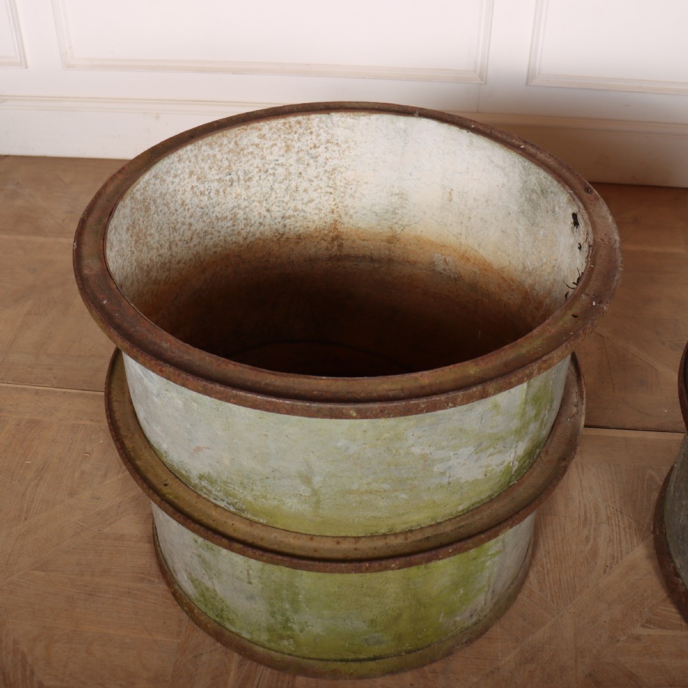 A pair of cylindrical weathered zinc planters featuring rusty iron rims and mid-bands with a distressed aged finish. View V