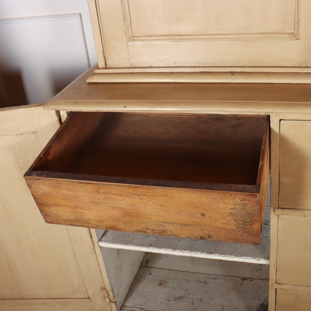 A large two-part painted pine housekeepers cupboard featuring three upper arched-panel doors above three central drawers flanked by side cupboards. View VIII