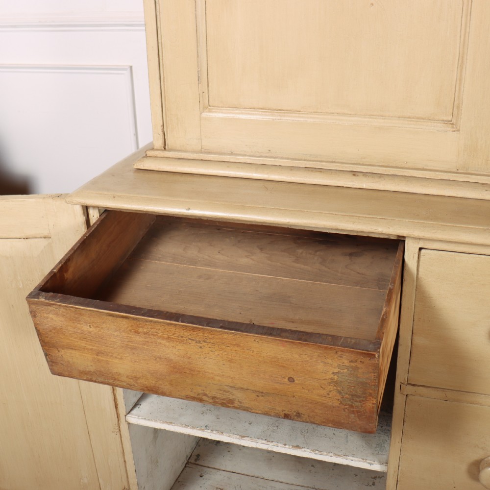 A large two-part painted pine housekeepers cupboard featuring three upper arched-panel doors above three central drawers flanked by side cupboards. View IX