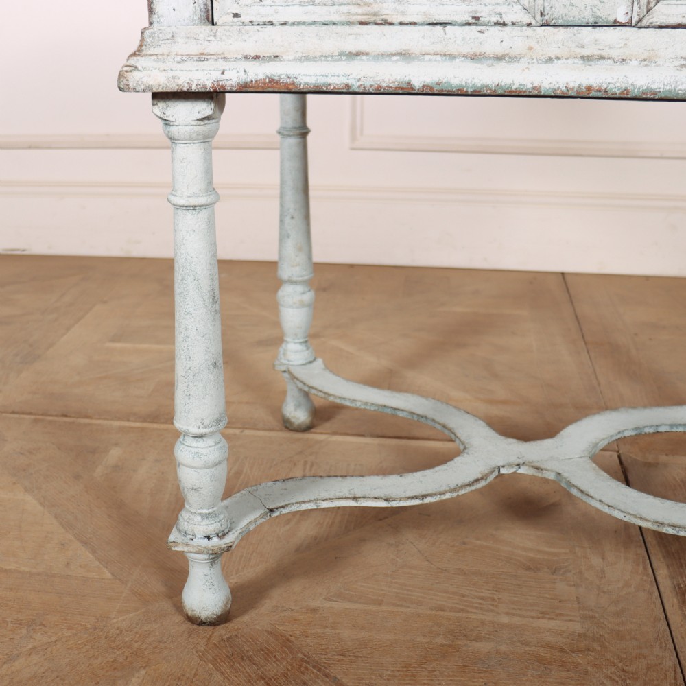 An 18th-century painted wooden side table featuring a pale blue distressed surface, turned legs, an X-frame stretcher, and two drawer fronts with brass pulls. View II