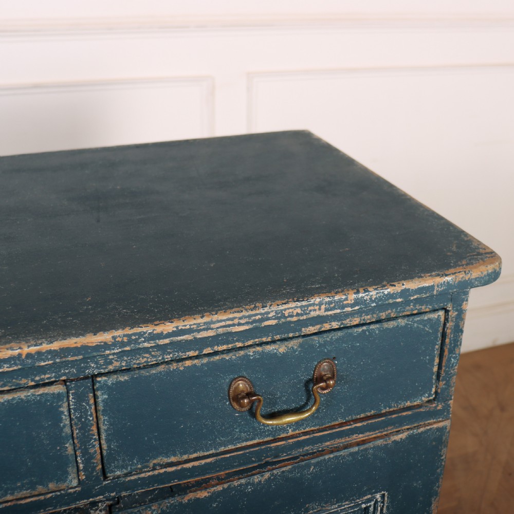 An antique Swedish four-door cupboard featuring a distressed blue painted finish, four top drawers with brass drop handles, and reeded vertical panel doors. View X