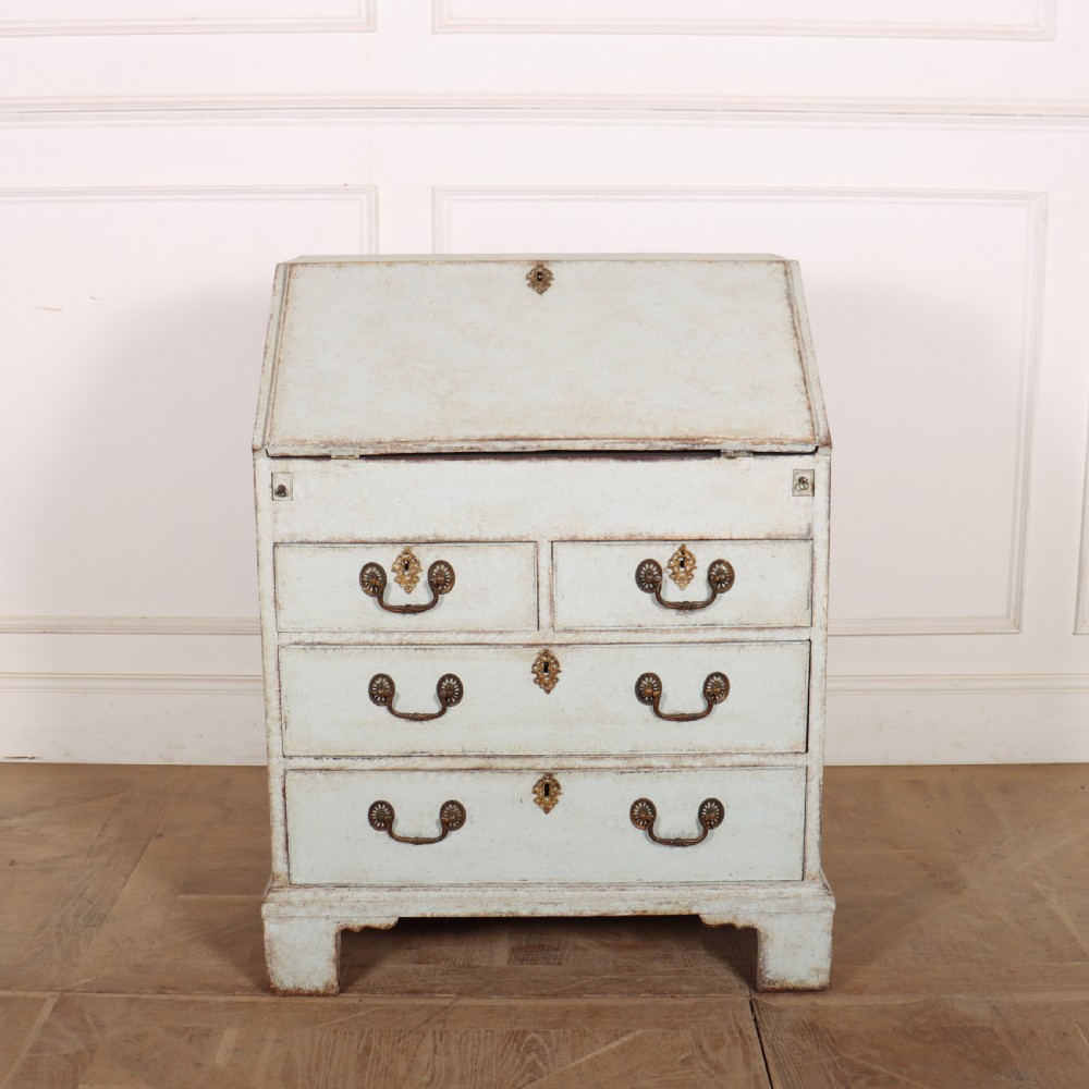 An 18th-century slant-front writing bureau with a distressed off-white painted finish, brass drop handles, and bracket feet.