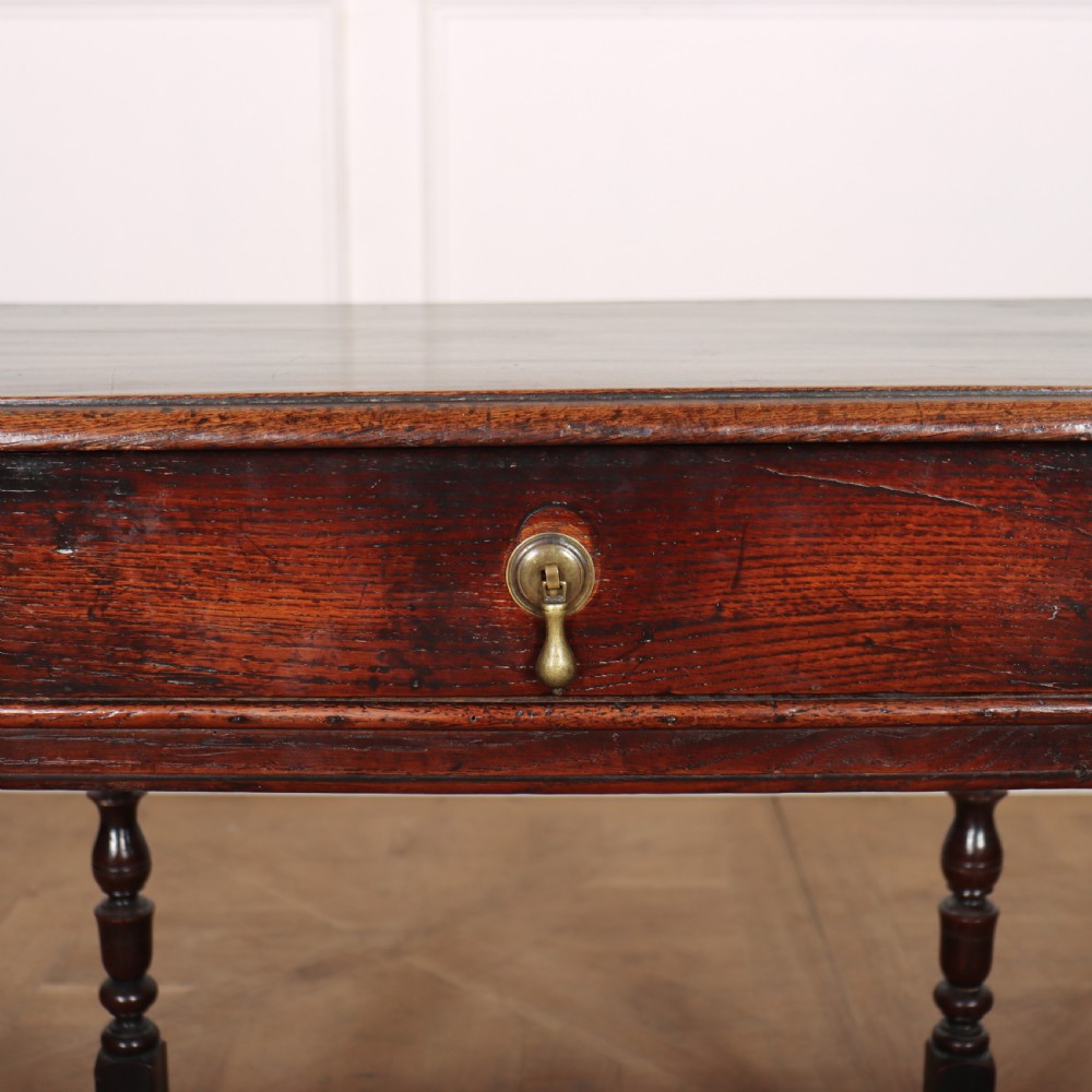 A dark oak 17th-century lamp table featuring a single drawer with a teardrop brass handle, turned baluster legs, and lower box stretchers. View V