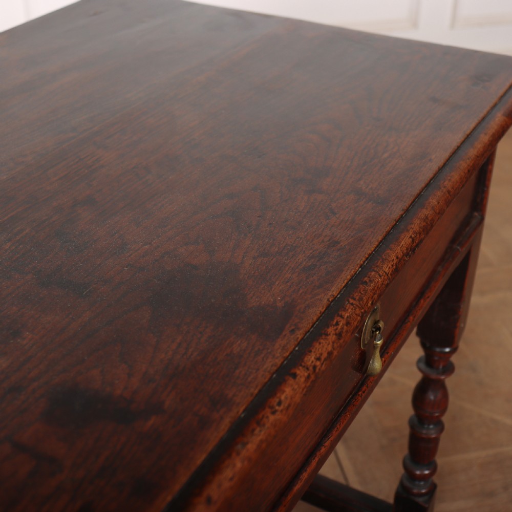 A dark oak 17th-century lamp table featuring a single drawer with a teardrop brass handle, turned baluster legs, and lower box stretchers. View VI