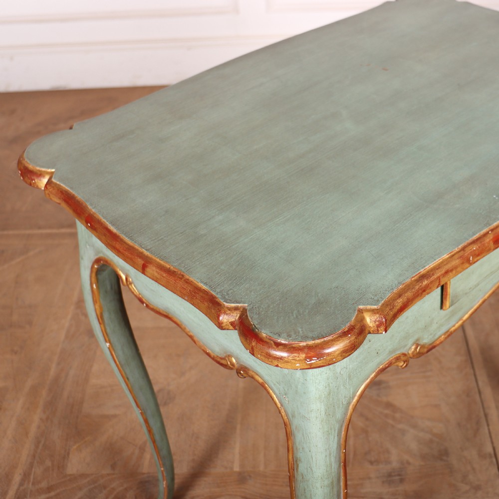 A sage green painted wooden side table featuring gilt trim, a serpentine edge, a single drawer, and four slender cabriole legs. View VI