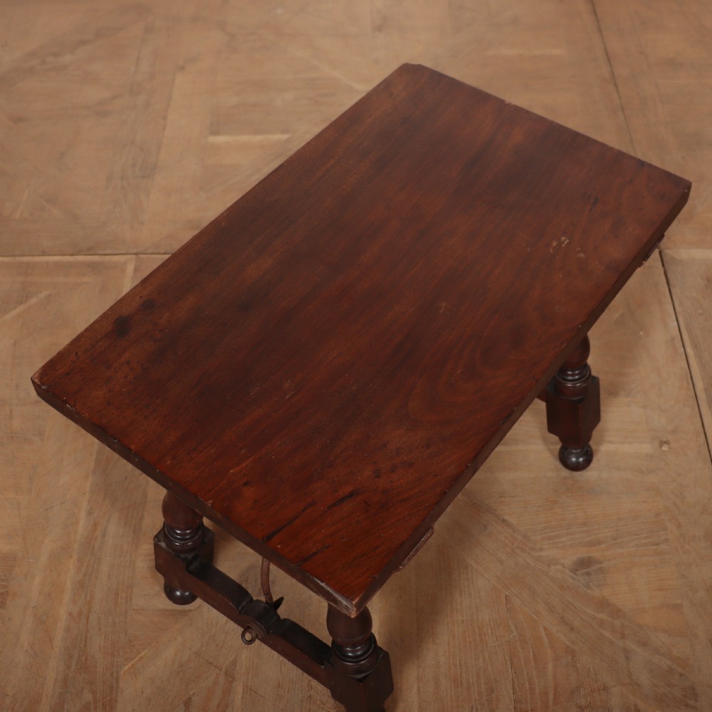 A dark walnut side table featuring turned legs supported by a curved wrought iron stretcher. View II