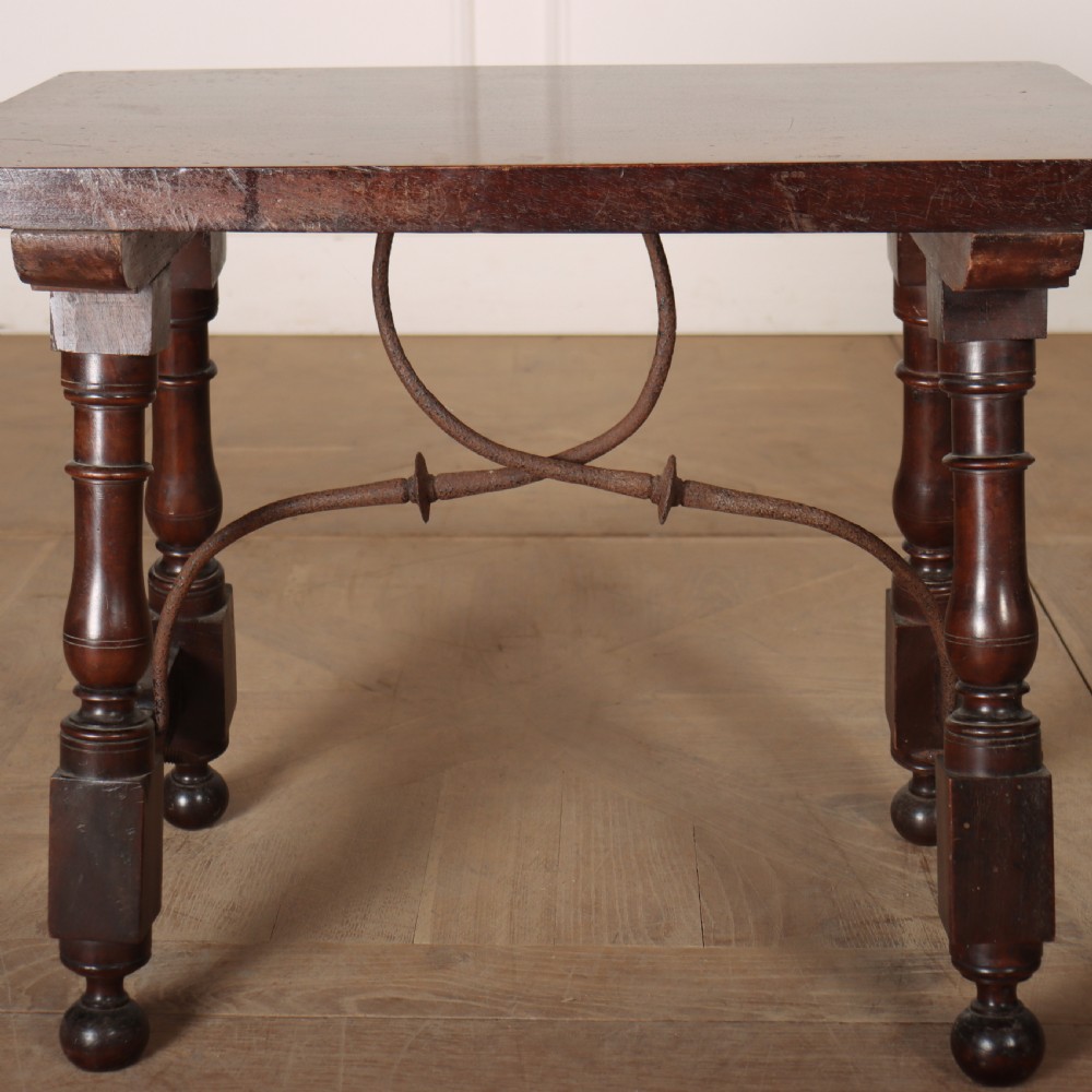 A dark walnut side table featuring turned legs supported by a curved wrought iron stretcher. View IV