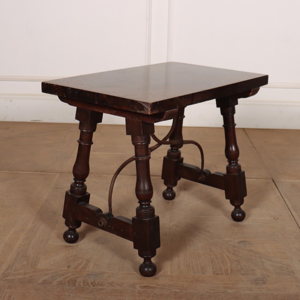 A dark walnut side table featuring turned legs supported by a curved wrought iron stretcher. View V