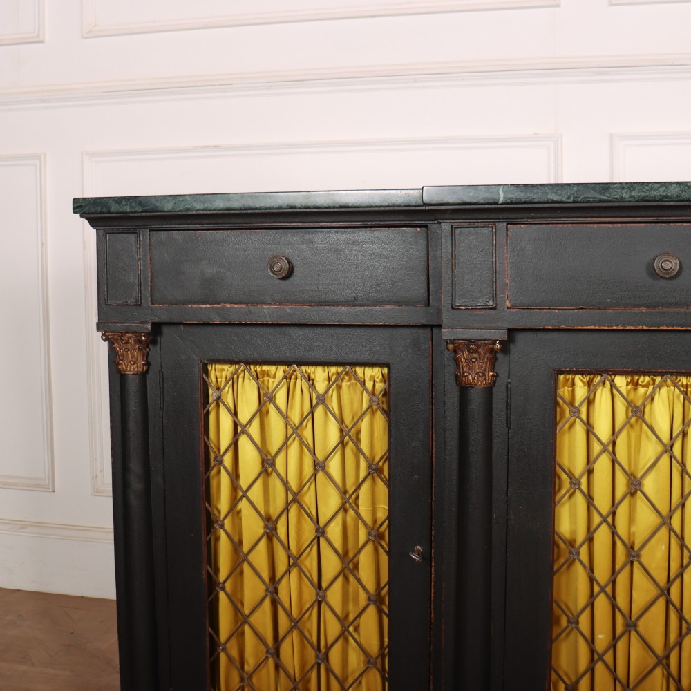 A painted English Regency breakfront dresser base featuring a green marble top, four frieze drawers, Corinthian columns, and mesh doors backed with yellow silk. View VI