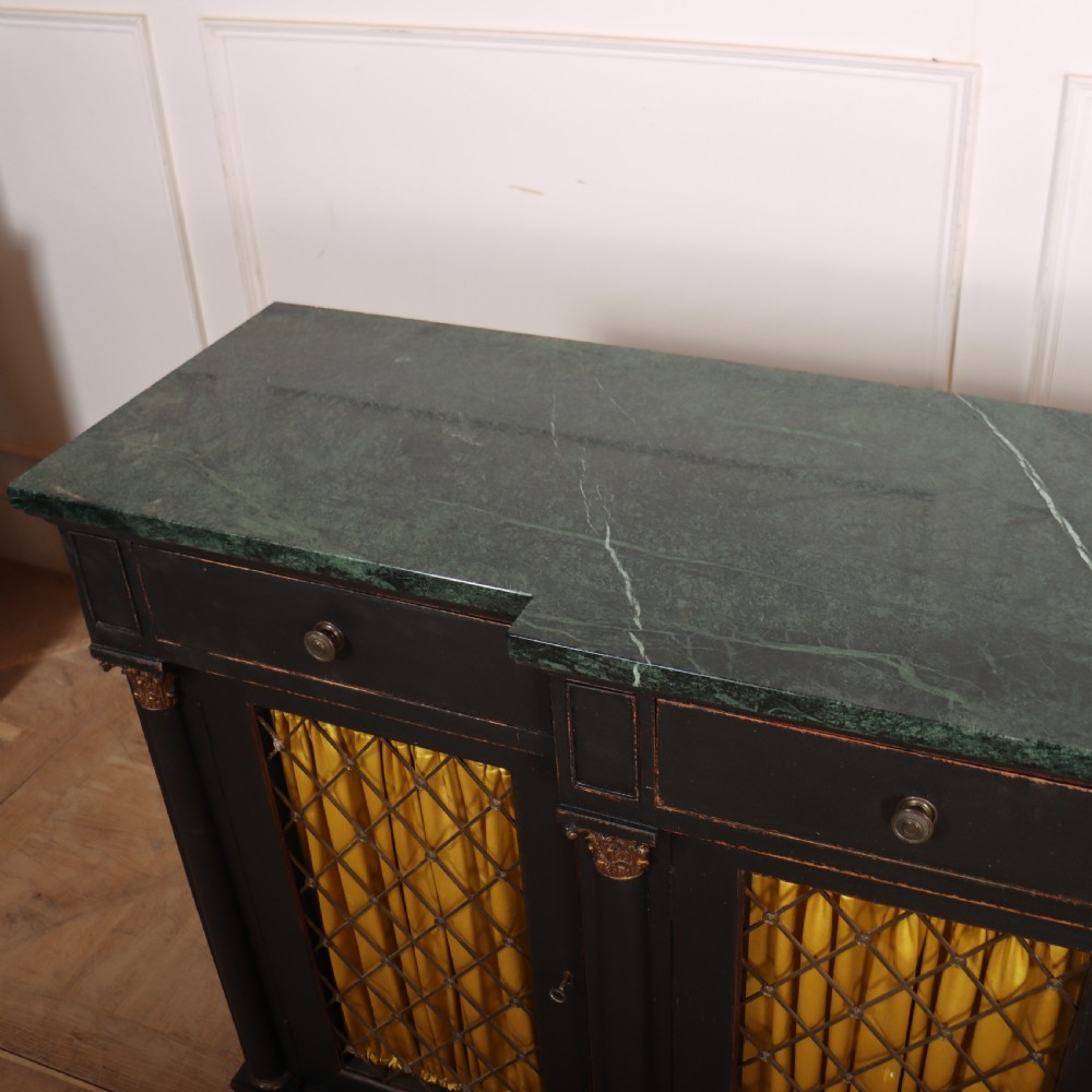 A painted English Regency breakfront dresser base featuring a green marble top, four frieze drawers, Corinthian columns, and mesh doors backed with yellow silk. View VII