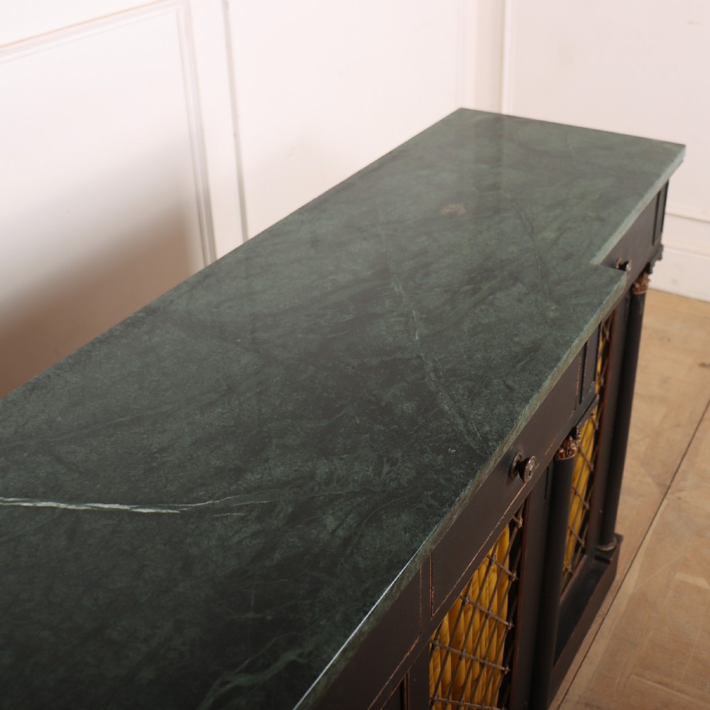 A painted English Regency breakfront dresser base featuring a green marble top, four frieze drawers, Corinthian columns, and mesh doors backed with yellow silk. View VIII