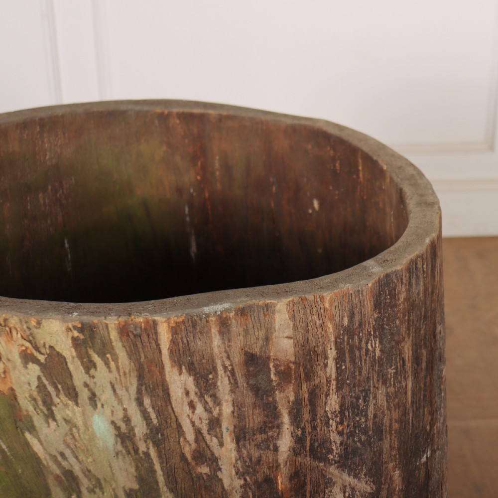 A vertical hollowed-out sycamore log planter with a weathered brown timber exterior and green patina highlights. View II