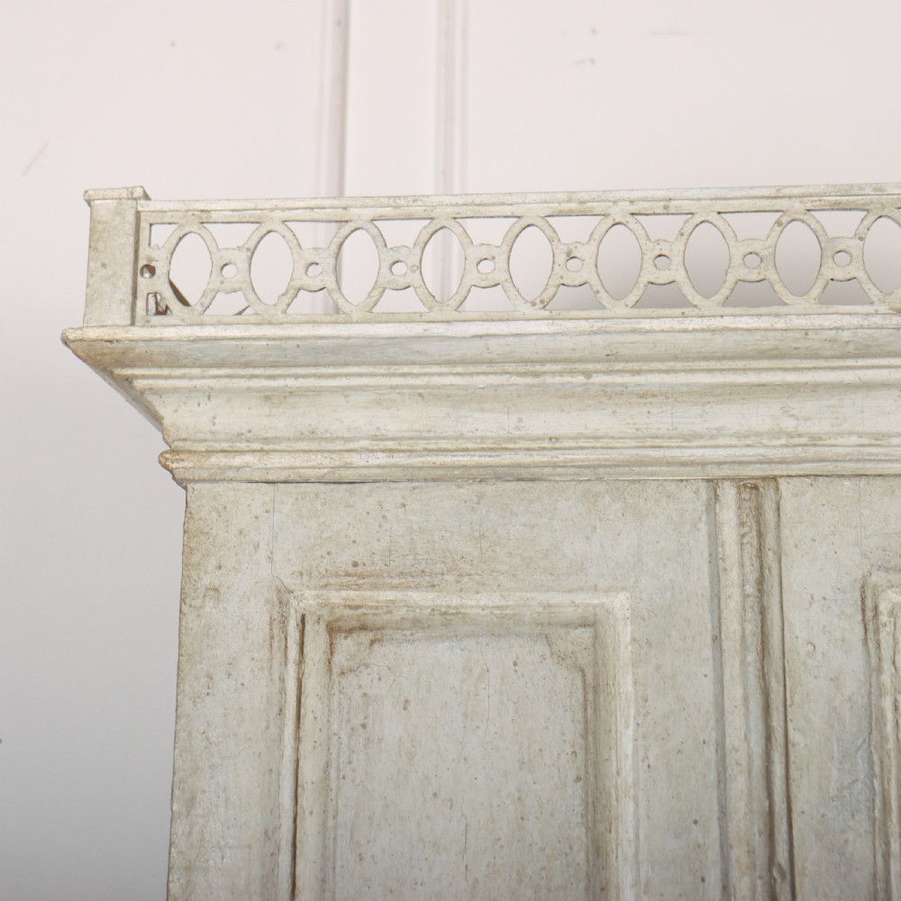 An off-white painted Danish bureau bookcase with a gallery-topped upper cupboard, stepped side drawers, a slant-front desk, and lower drawers fitted with brass lion-head ring handles. View VI