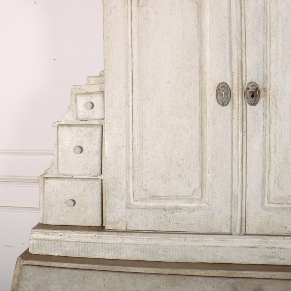 An off-white painted Danish bureau bookcase with a gallery-topped upper cupboard, stepped side drawers, a slant-front desk, and lower drawers fitted with brass lion-head ring handles. View VIII
