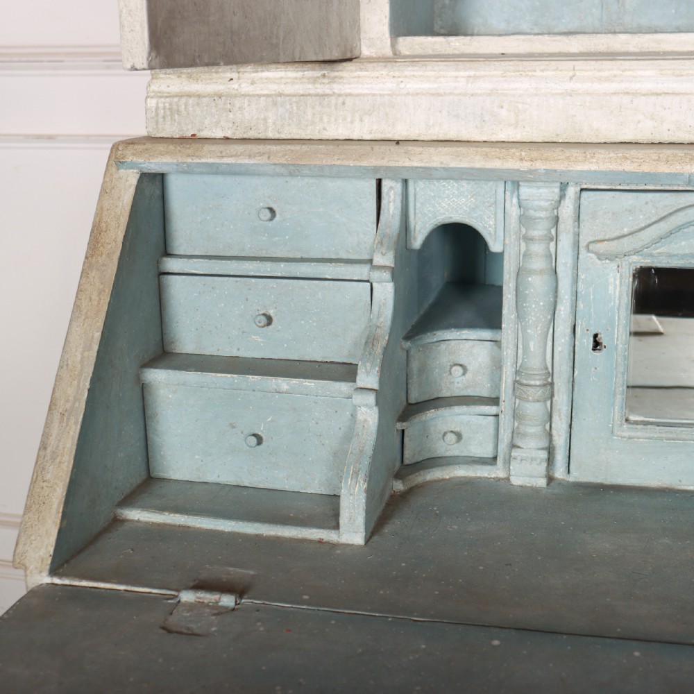An off-white painted Danish bureau bookcase with a gallery-topped upper cupboard, stepped side drawers, a slant-front desk, and lower drawers fitted with brass lion-head ring handles. View XI