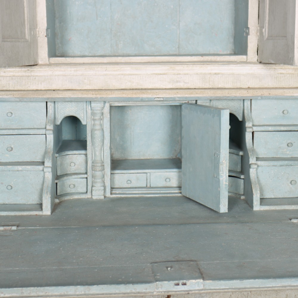 An off-white painted Danish bureau bookcase with a gallery-topped upper cupboard, stepped side drawers, a slant-front desk, and lower drawers fitted with brass lion-head ring handles. View XIII