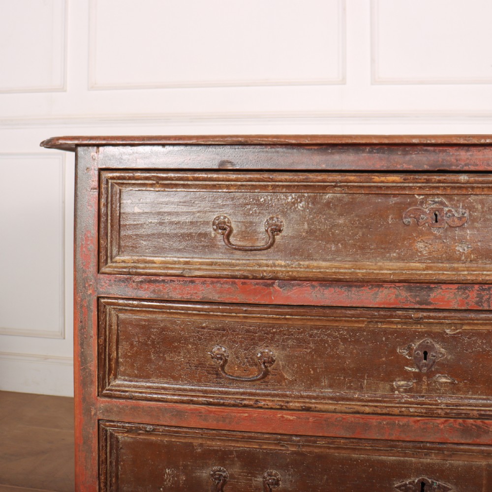 An antique three-drawer Italian commode featuring a painted red and brown finish, carved cabriole legs, and metal drop handles. View II
