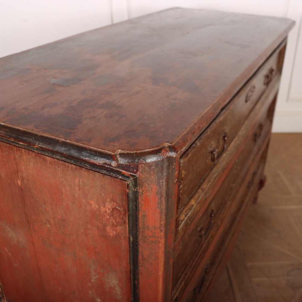 An antique three-drawer Italian commode featuring a painted red and brown finish, carved cabriole legs, and metal drop handles. View VIII