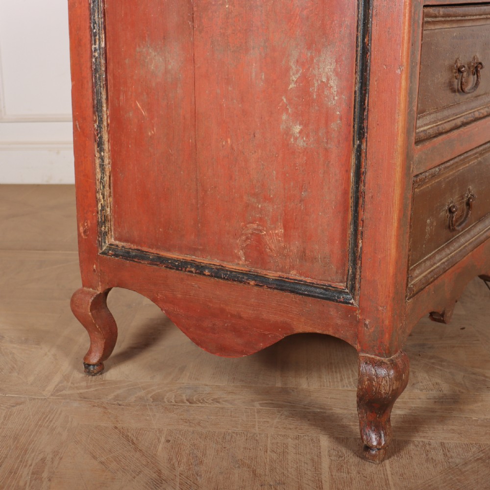 An antique three-drawer Italian commode featuring a painted red and brown finish, carved cabriole legs, and metal drop handles. View IX