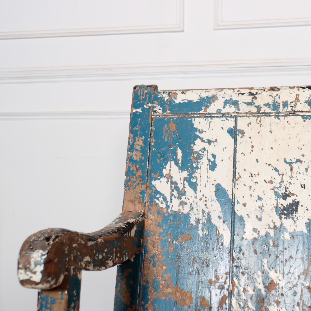 An antique English high back wooden settle bench featuring distressed layers of blue and cream paint with visible exposed timber. View IV