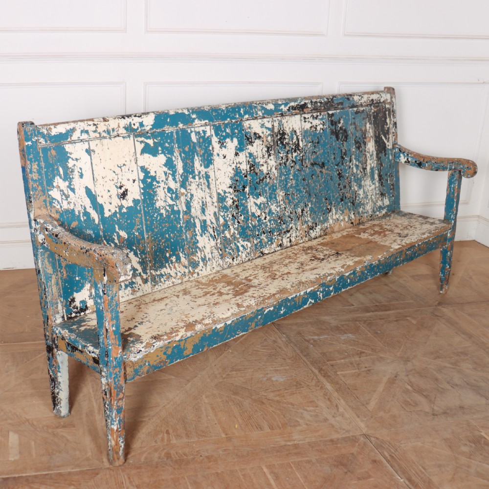 An antique English high back wooden settle bench featuring distressed layers of blue and cream paint with visible exposed timber. View VIII