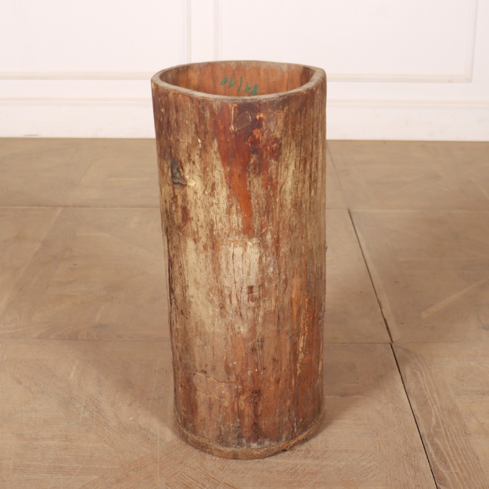 A cylindrical rustic vessel crafted from a hollowed-out tree trunk with weathered natural wood grain. View II