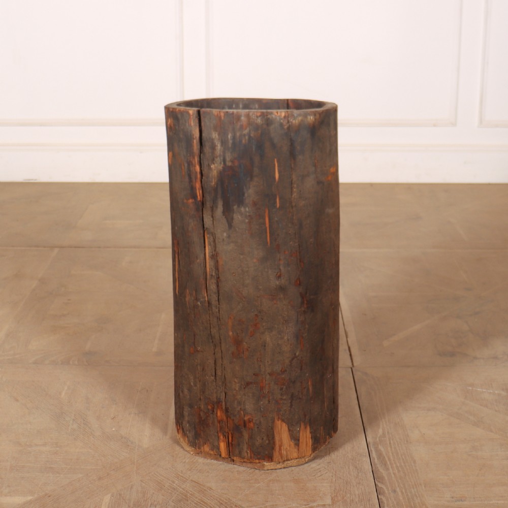 A vertical hollowed-out tree trunk displaying dark weathered timber with natural grain splits.