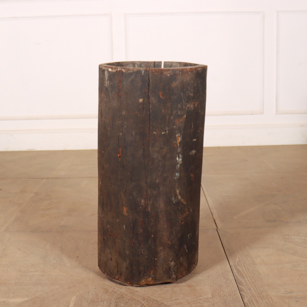 A vertical hollowed-out tree trunk displaying dark weathered timber with natural grain splits. View III