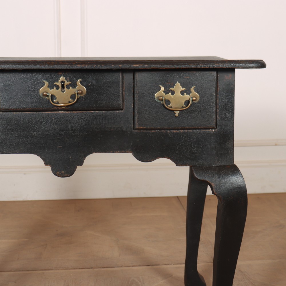 A black painted antique lowboy table featuring three drawers with brass batwing handles, a shaped apron, and cabriole legs. View III