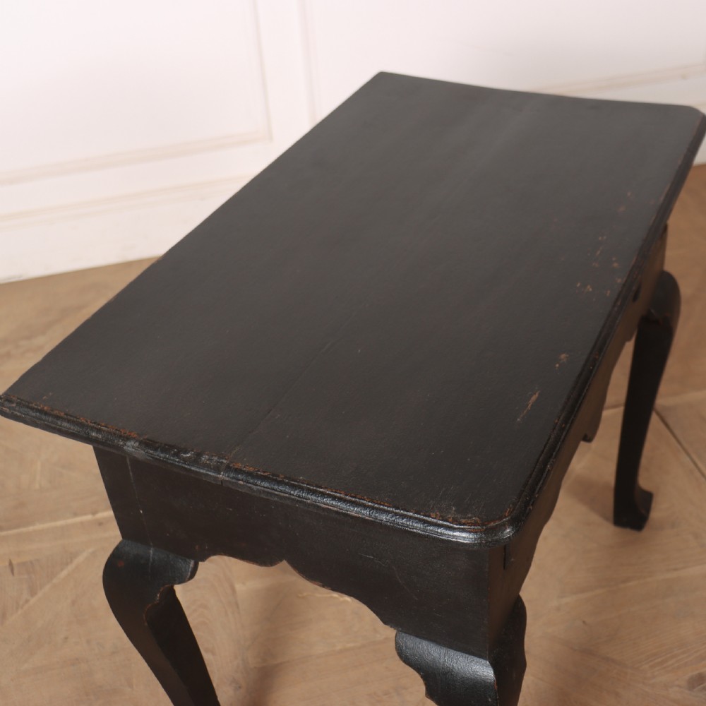 A black painted antique lowboy table featuring three drawers with brass batwing handles, a shaped apron, and cabriole legs. View X