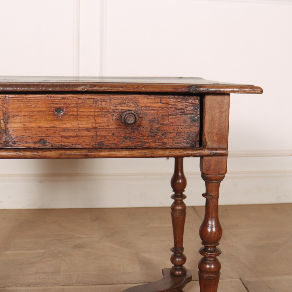 An 18th-century oak side table with a single frieze drawer, turned legs, wooden knobs, and a shaped lower stretcher. View V