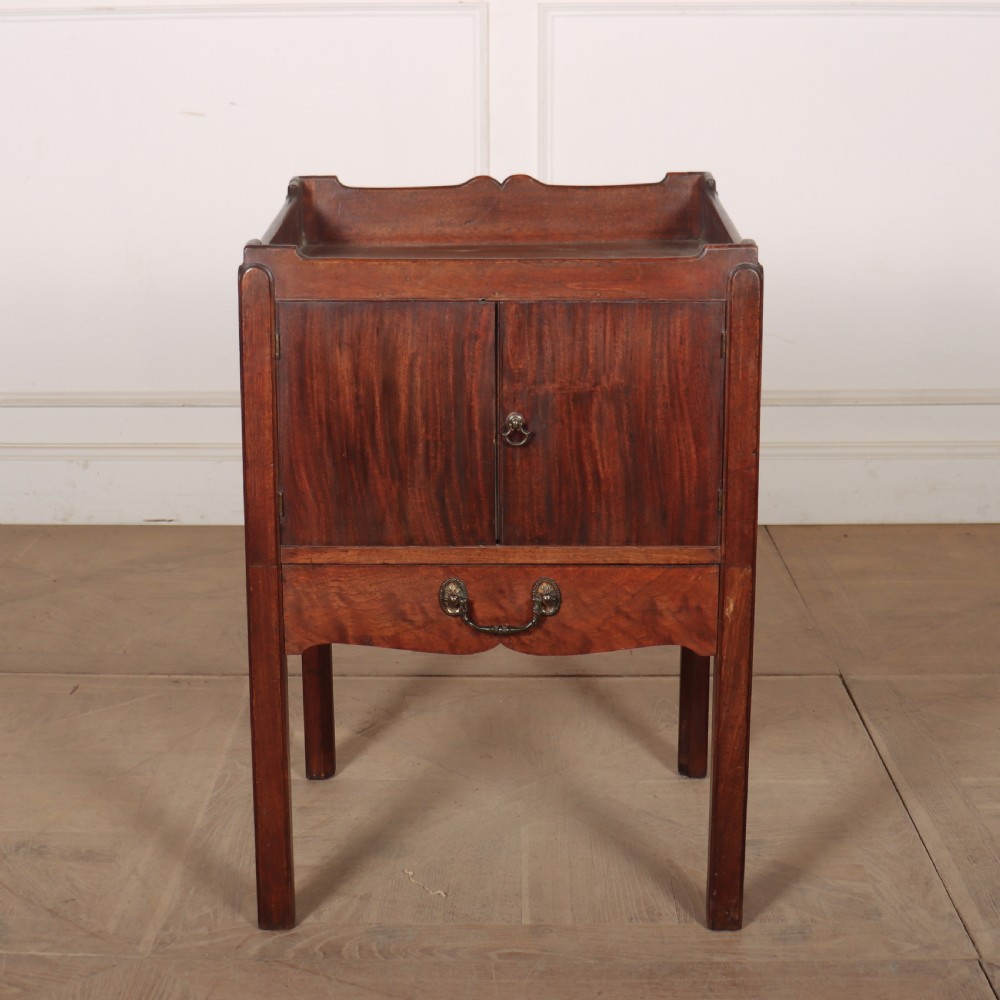 A Georgian mahogany tray-top bedside table featuring a double-door cupboard above a single drawer with a brass drop handle, supported by straight square legs.