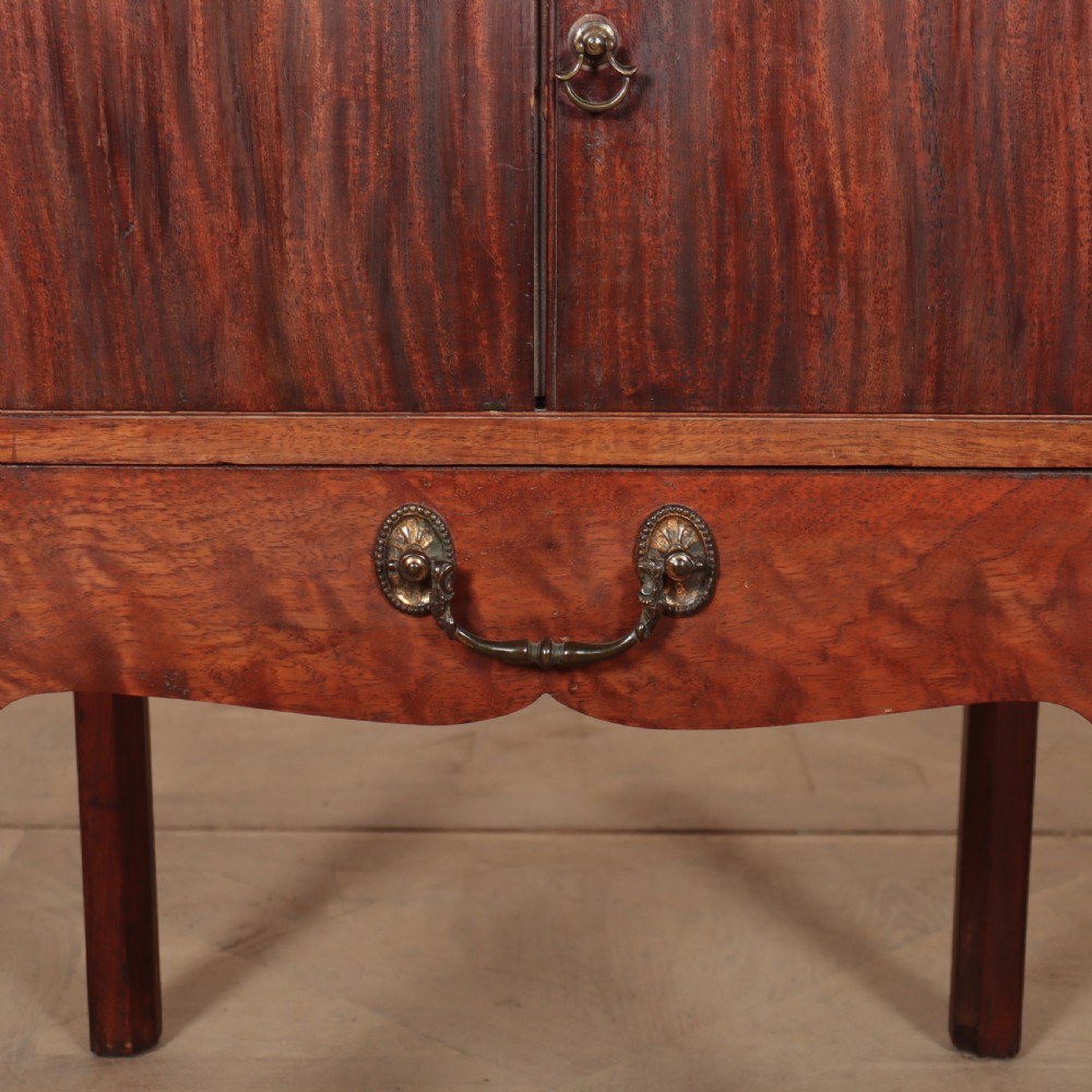 A Georgian mahogany tray-top bedside table featuring a double-door cupboard above a single drawer with a brass drop handle, supported by straight square legs. View II