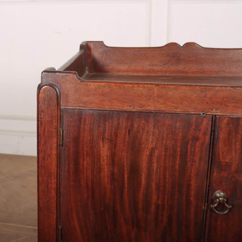 A Georgian mahogany tray-top bedside table featuring a double-door cupboard above a single drawer with a brass drop handle, supported by straight square legs. View IV